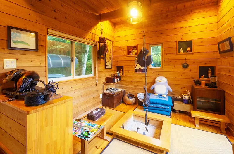 「那須山荘せせらぎ」の囲炉裏と自在鉤のある総板張りの山小屋風内観