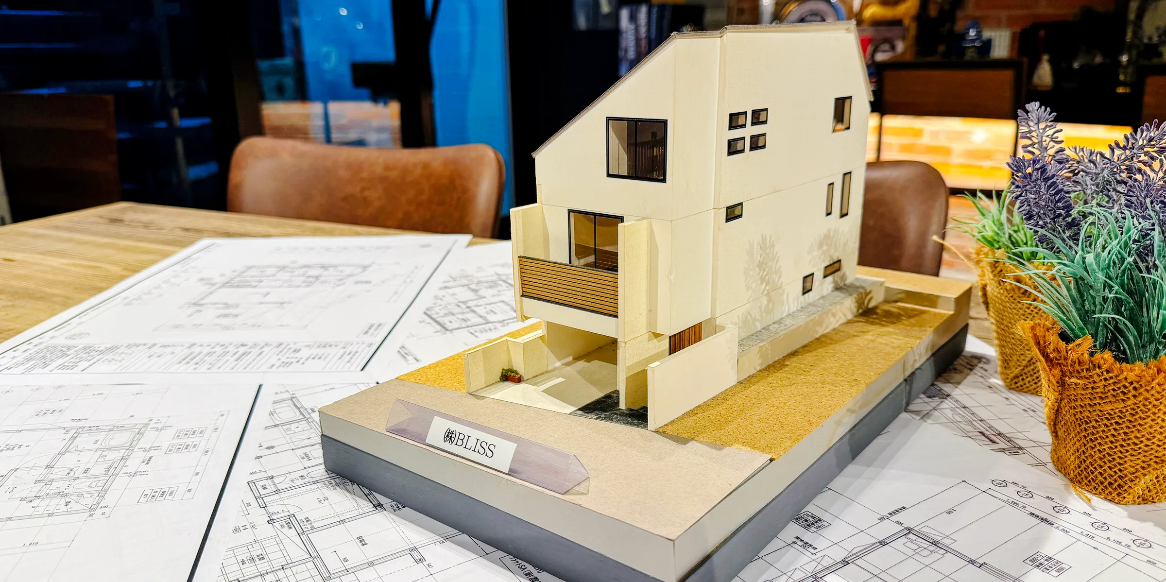 図面の上に置かれた片流れ屋根の住宅模型