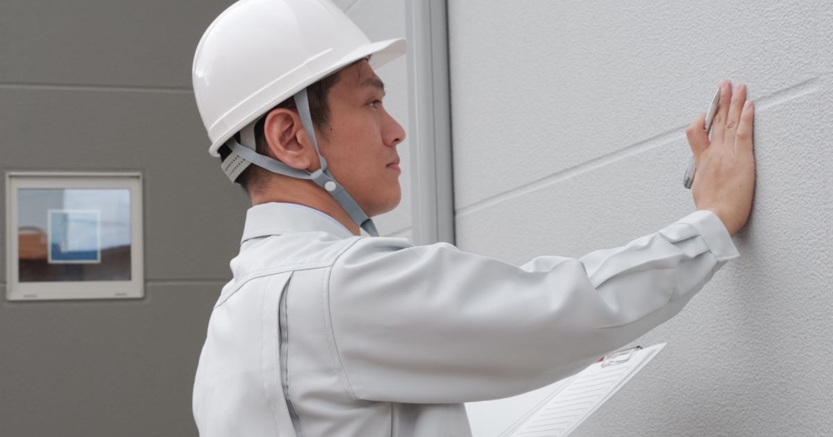 外壁の補修を確認している施工会社の男性