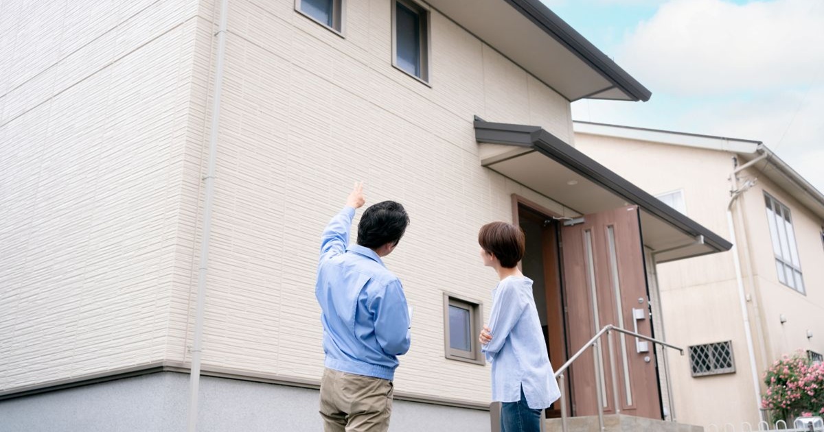 屋根リフォームについて相談しているリフォーム会社の男性と女性