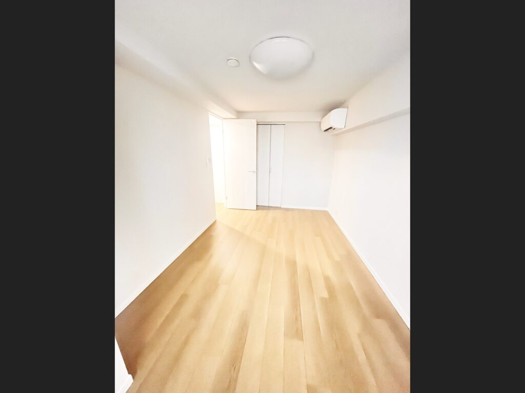 リフォーム後の洋室。カーペットからフローリングに張替え、白い壁とクローゼットで明るく清潔な空間に
