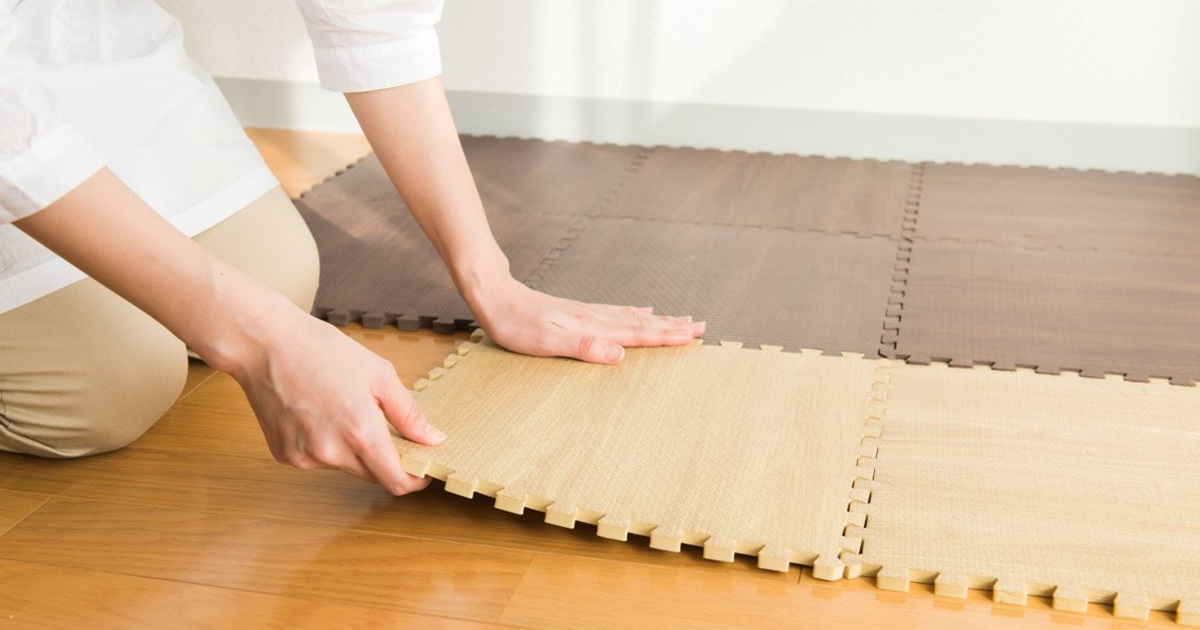 自宅の床に防音シートを貼っている女性