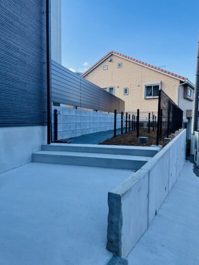 階段とフェンスを設けた建物脇のアプローチ