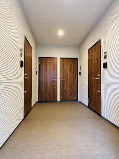 木目調の玄関ドアが並ぶ2階の共用廊下