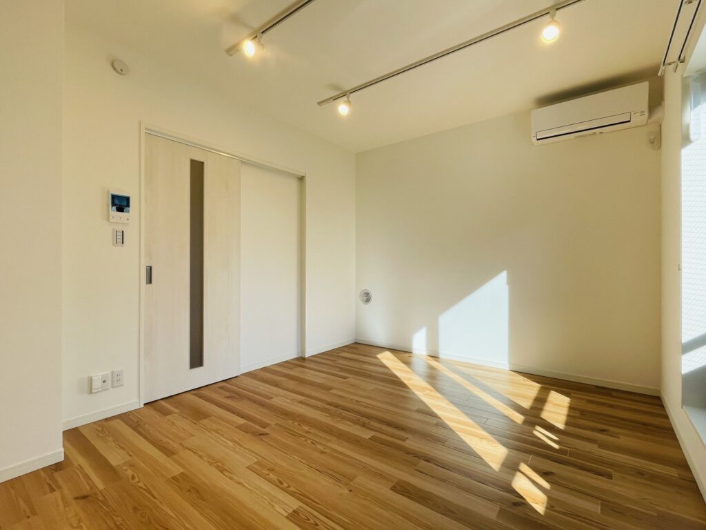 ライティングレールとエアコンを備えた賃貸住戸の洋室