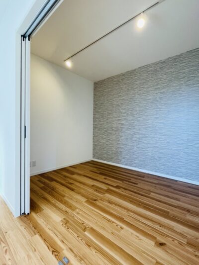 グレーのアクセントクロスを張った賃貸住戸の洋室